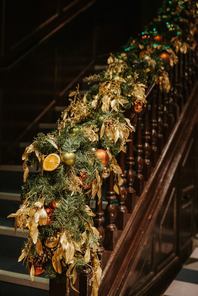 Christmas decorations adorn the stairs of Amazing Grace London, creating a festive and welcoming atmosphere