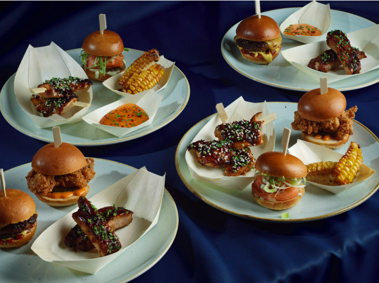 Amazing Grace London served burgers, glazed chicken wings, corn on the cob, and dipping sauce, creating a luxurious feast.